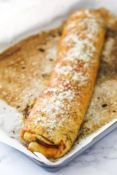 some food that is sitting on a pan with it's end covered in powdered sugar