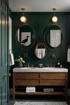 a bathroom with green walls and two round mirrors