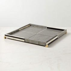 a black and white striped tray with gold handles