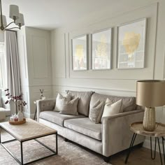 a living room with couches, tables and pictures on the wall in it's corner