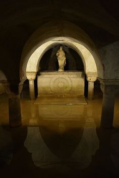 a statue is sitting in the middle of a tunnel