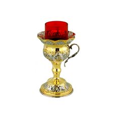 a golden cup with a red candle in it