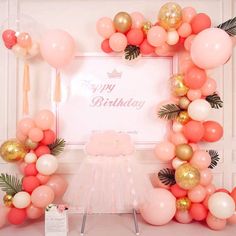 a pink and gold birthday party with balloons, streamers, palm leaves and a photo frame