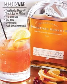 a bottle of woodford reserve punch sitting next to a glass filled with orange slices