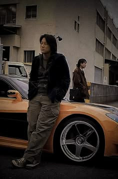 a man standing next to a yellow sports car