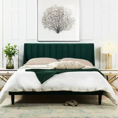 a bedroom with a green headboard and white sheets on the bed, next to a plant