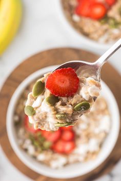 a spoon full of oatmeal with strawberries on top