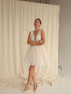 a woman standing in front of a white backdrop