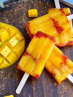 several popsicles are sitting on a plate with mango slices