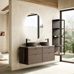 a bathroom with two sinks and a round mirror