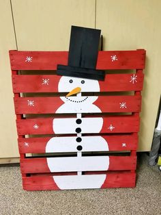 a wooden pallet with a snowman painted on it