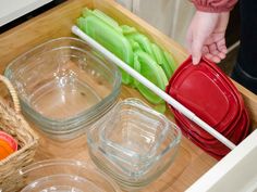 a drawer with bowls and chopsticks in it that is filled with plastic containers