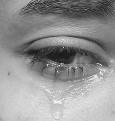 a man's eye with water drops coming out of it