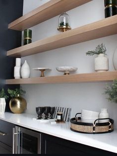 the shelves in this kitchen are filled with vases and bowls, plates and cups