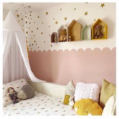 a child's bedroom decorated in pink, white and gold with stars on the wall