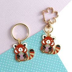 a pair of red panda keychains on a blue and white background