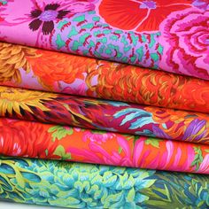 a stack of colorful fabrics with flowers on them