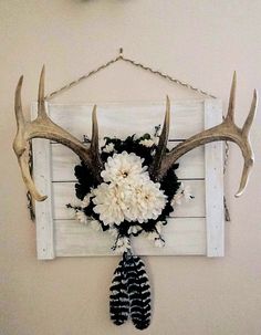 the antlers are hanging on the wall with flowers