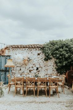 an outdoor dining table set up with balloons in the air