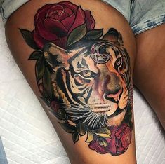 a woman's thigh with a tiger and rose tattoo on it