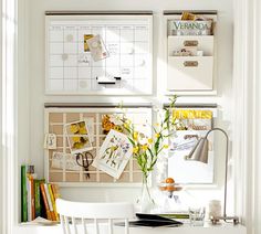 a white desk and chair in front of a wall with calendars on the walls