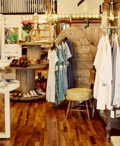 the inside of a clothing store with wooden floors