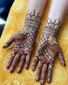 two hands with henna tattoos on them