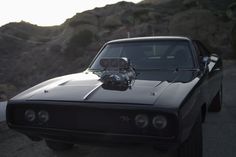 an old muscle car is parked on the side of the road with its hood up