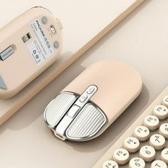 a computer mouse sitting next to an old typewriter on top of a white table