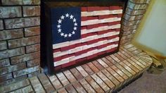 an american flag made out of wood sitting on top of a brick fireplace mantel