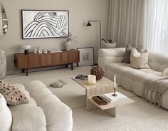 a living room filled with white furniture and decor