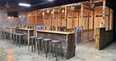 the bar is made out of pallet wood and has stools in front of it