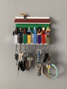 a lego key holder with many keys hanging from it's hooks on the wall