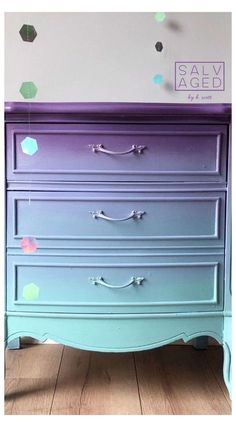 an old dresser painted purple and green with confetti on the wall behind it