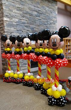 mickey and minnie mouse balloons on display in front of a fireplace