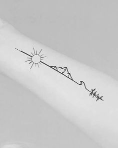 a person with a tattoo on their arm that has the sun and mountains in it