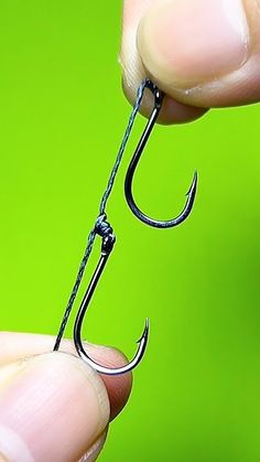 a person holding a fishing hook in their hand