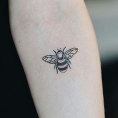 a small bee tattoo on the left arm