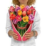 a woman holding a bouquet of colorful flowers