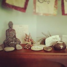 a wooden table topped with figurines and other items on display next to wall hangings