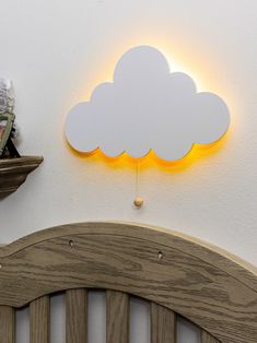 a wooden headboard with a cloud shaped light above it