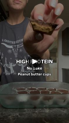 a man is holding up some food in his hand with the words high protein no bake peanut butter cups