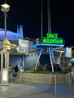 the entrance to space mountain is lit up at night