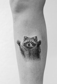 a raccoon tattoo on the leg