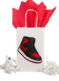 a white bag with a red and black shoe on it next to some gums