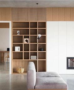 a living room with a couch, book shelf and fire place in it's center