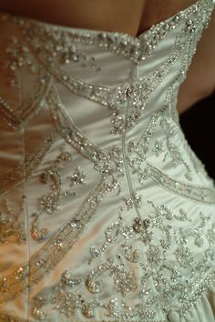 the back of a wedding dress with beading on it