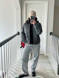 a woman taking a selfie while standing on the stairs in front of a door