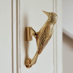 a gold bird door handle on a white door