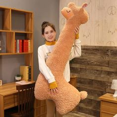 a woman holding up a large stuffed animal